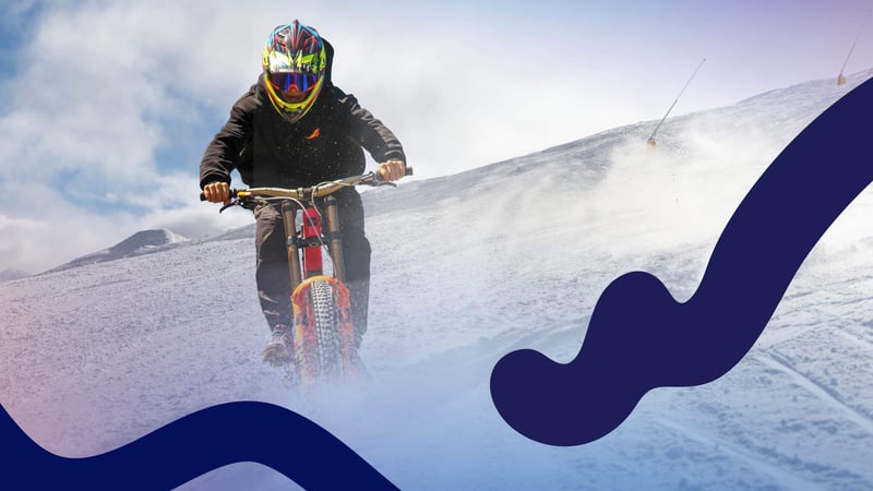 Person biking downhill on snow.
